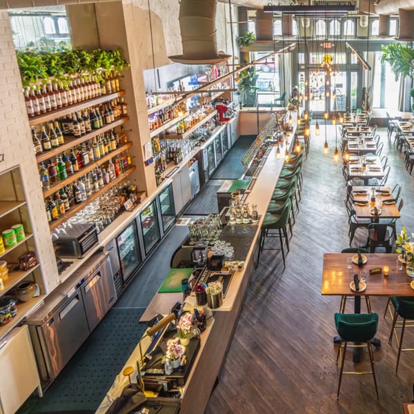 Overhead view of Arepas Latin Cuisine, showing a long bar with stools and dining tables.