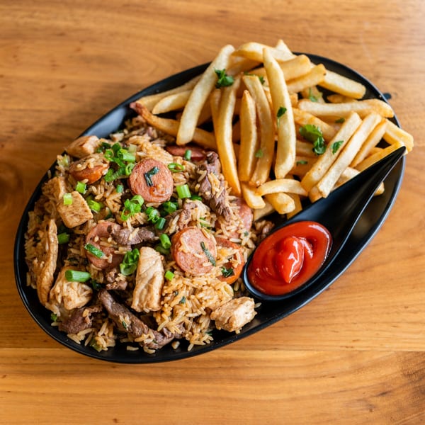 Venezuelan fried rice with chicken, beef, sausage, and scallions, served with french fries and ketchup.