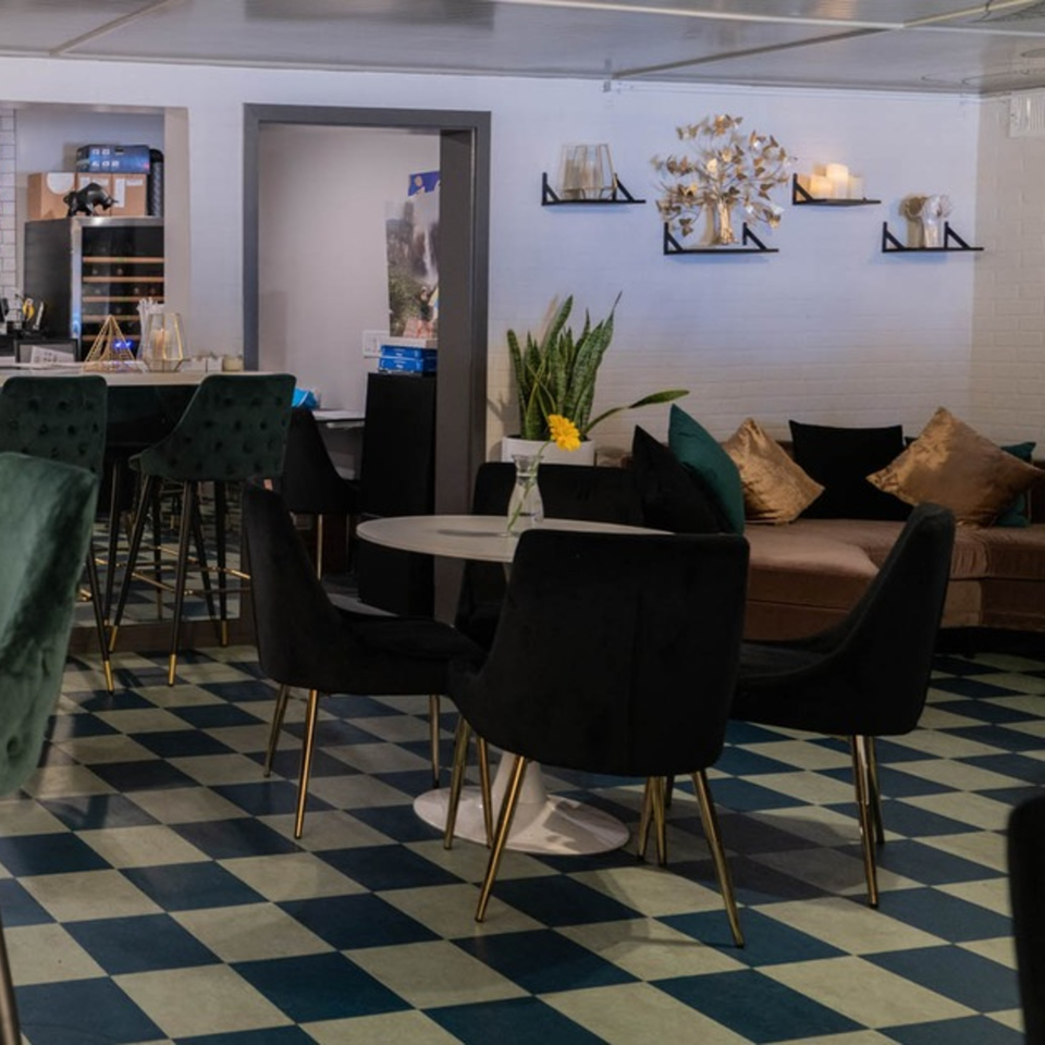 Interior of Arepas Latin Cuisine, featuring a bar, dining tables, and a lounge area with a sofa.