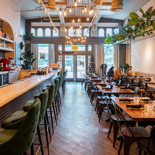 Interior of Arepas Latin Cuisine, featuring a bar, dining tables, and a Christmas tree.